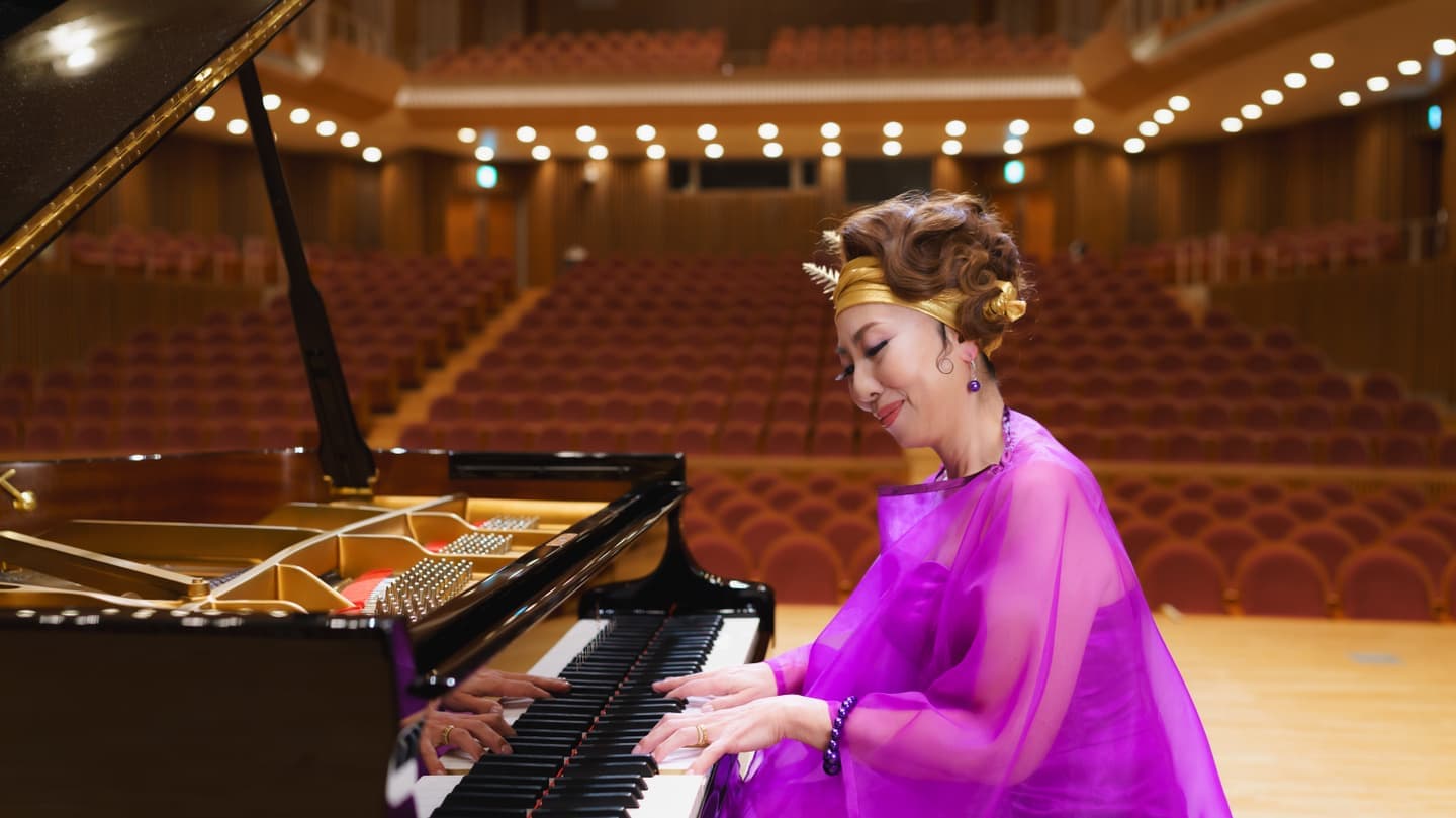 ホールを背景にピアノを演奏している女性